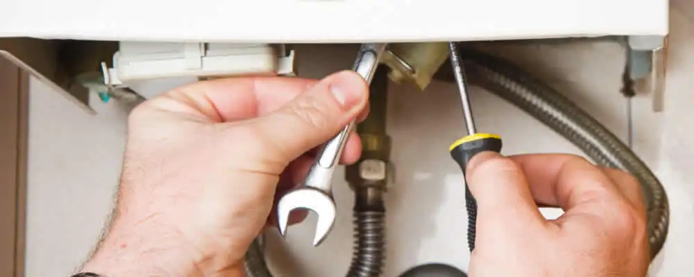 Boiler repair technician tightening pipe fittings and connections in Saint Charles, MO