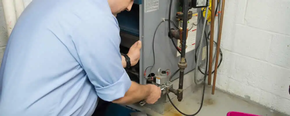 Furnace repair technician inspecting and servicing a home heating system in Saint Charles, MO