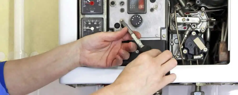 Heating repair technician adjusting boiler controls and components in Saint Charles, MO
