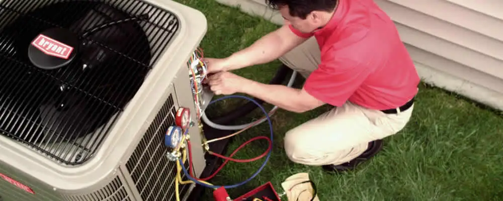 HVAC technician servicing an outdoor air conditioner unit in Saint Charles, MO