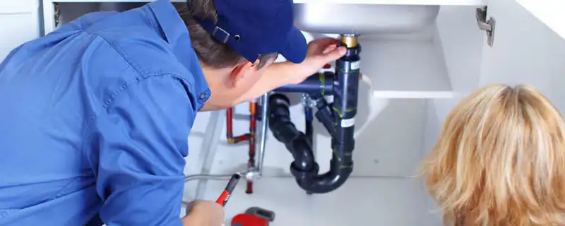Plumber repairing under-sink drain pipes and fittings in Saint Charles, MO